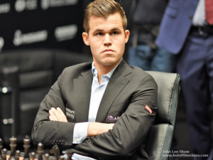 Magnus Carlsen, sitting with his arms folded, ready to start game 1. Photograph by John Lee Shaw © www.hotoffthechess.com.